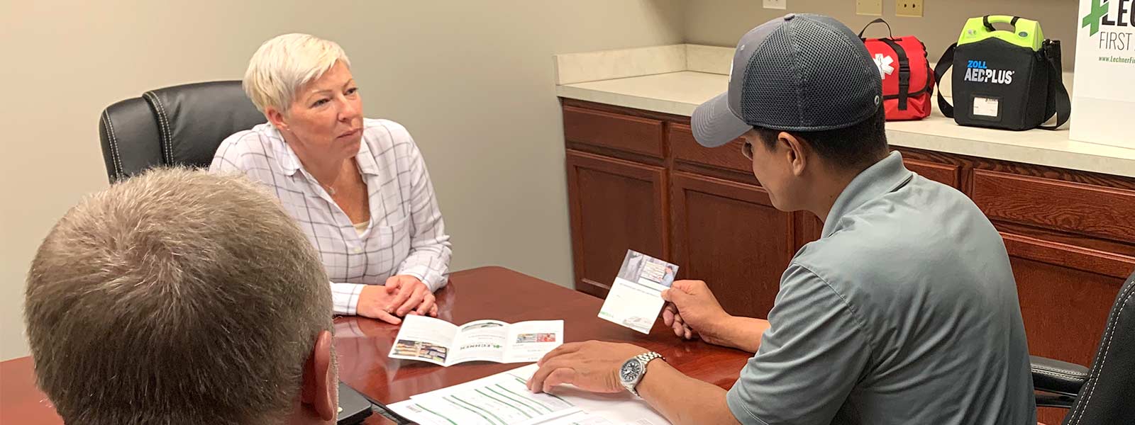 Lechner First Aid Service Representatives discussing with a business owner how a Lechner First Aid Service Program can help keep employees safe.