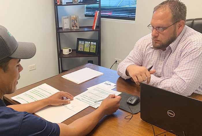 A Lechner First Aid Service Representative and a business owner sitting at a desk discussing the benefits of a Lechner First Aid Service. 