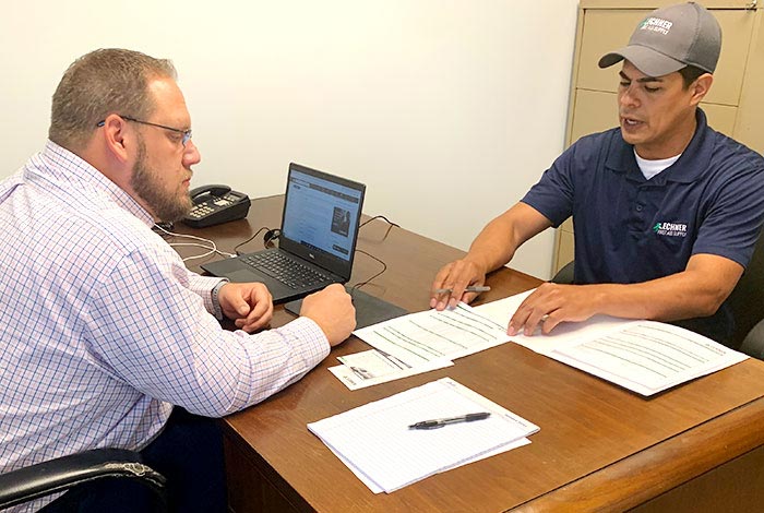 Lechner First Aid Sales Representatives discussing the benefits of a Lechner First Aid Program/ First Aid Service with a business owner.