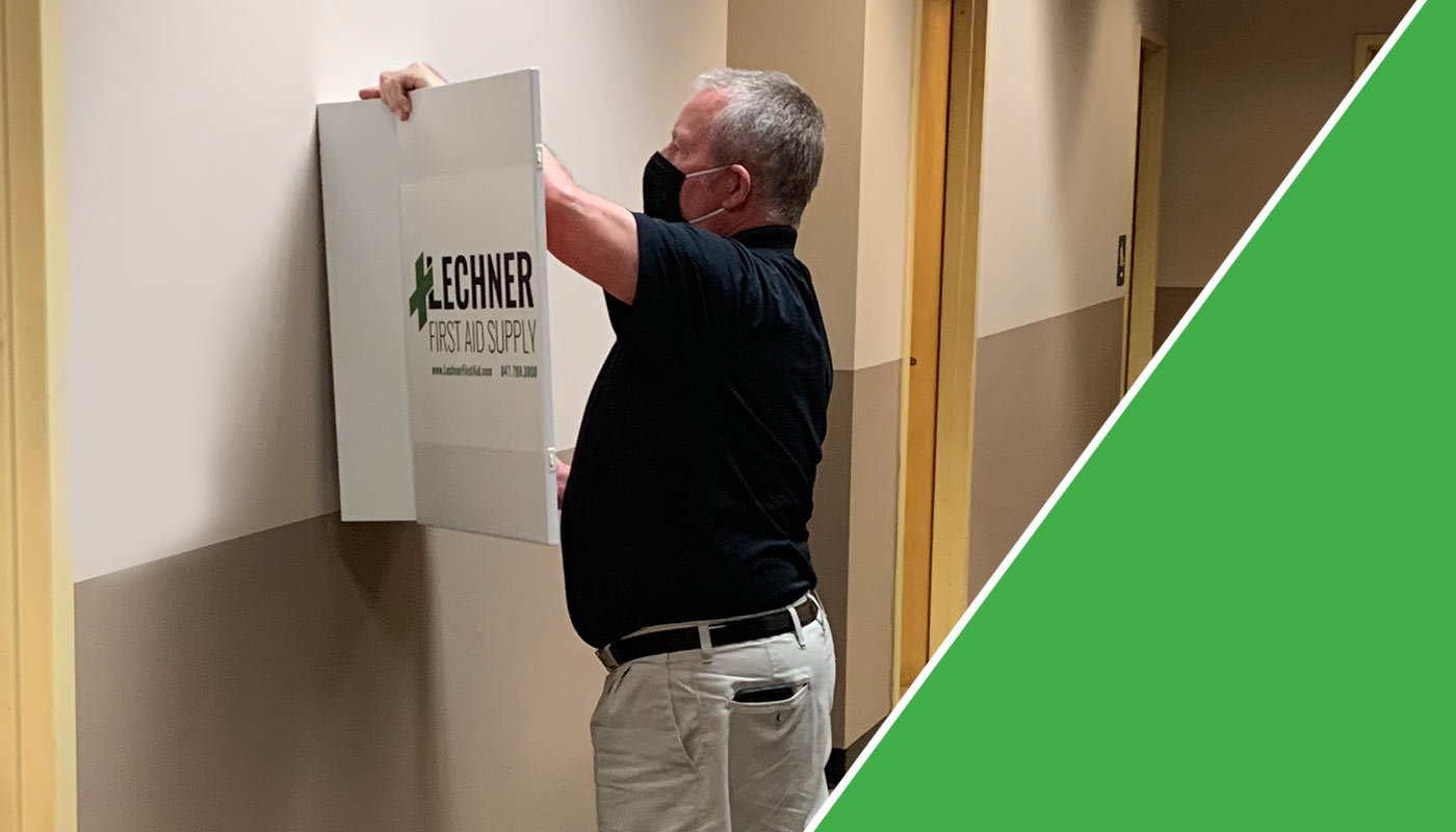 Lechner First Aid Sales Representative hanging a Lechner First Aid kit on the wall. 