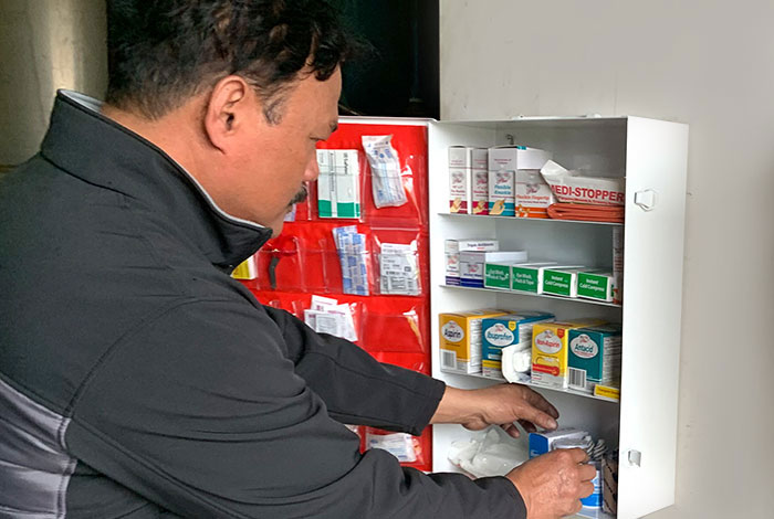 Lechner First Aid Program employee servicing required first aid safety materials and ppe. 