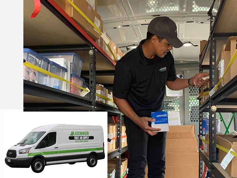 Lechner First Aid Service Representative delivering first aid, PPE, and other safety products to customers. Standing in a Lechner First Aid truck with first aid supplies.
