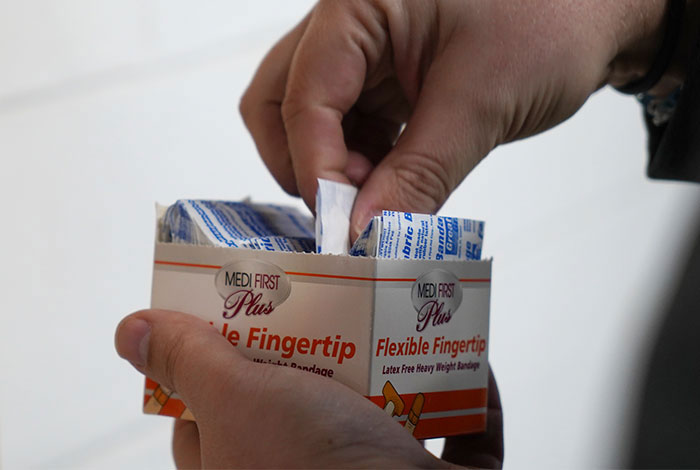 Hand pulling out a bandage from a package.
