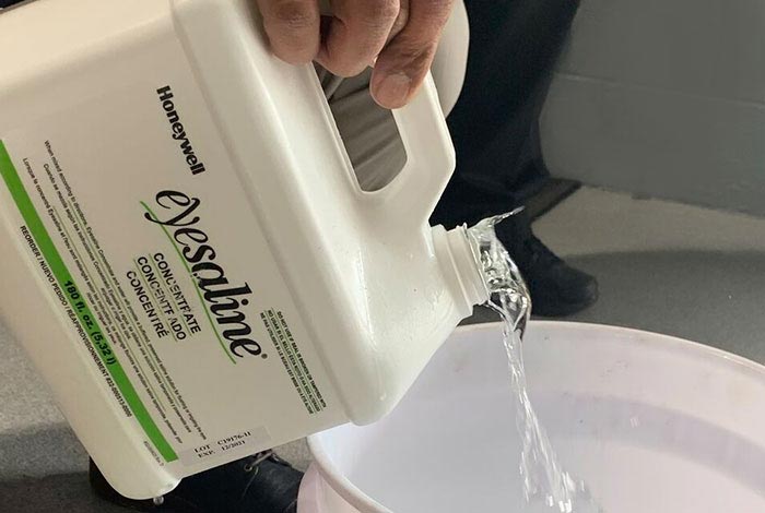 Pouring eyesaline solution out of the container.